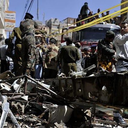 Policemen collect wreckage of the crashed plane in Sanaa, Yemen. Photo: Xinhua