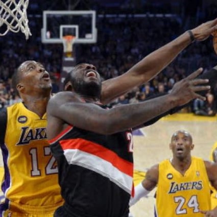 Los Angeles Lakers centre Dwight Howard, left, blocks the shot of Portland Trail Blazers centre J.J. Hickson as guard Kobe Bryant (second from right) and forward Earl Clark (right) look on. Photo: AP