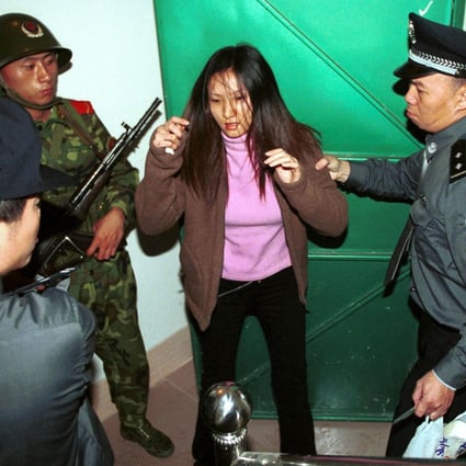 A police detain a suspected prostitute in Dongguan.