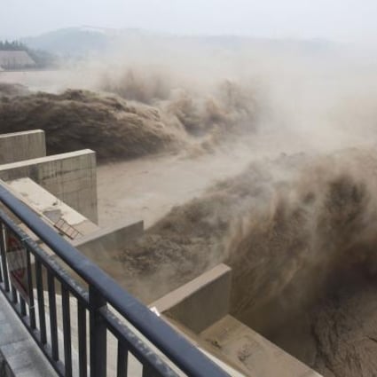 Chinese paramilitary guard watching over giant gushes of water being released from the Xiaolangdi dam. Photo: AFP
