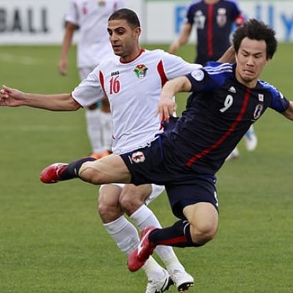 Japan's Okazaki fights for the ball against Jordan's Othman at King Abdullah stadium in Amman. Photo: Reuters