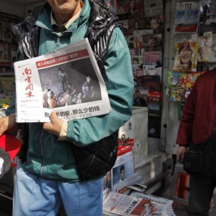 A man displays a copy of the Southern Weekly at a newsstand in Guangzhou, Jan. 10, 2013. (Photo: AP)