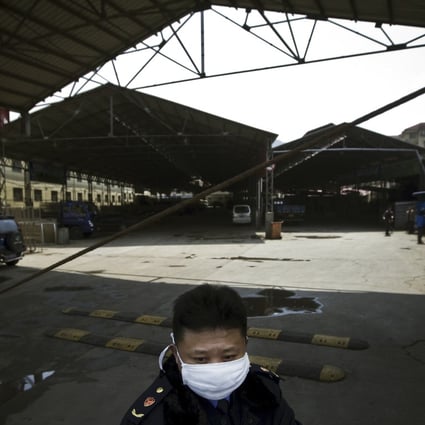 A security guard wearing a face mask stands guard at a poultry market which has been closed by local government officials in Nanjing, eastern  China's Jiangsu province. Photo: AP