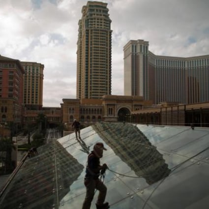 Workers clean the glass roof of a shopping mall in front of the Las Vegas Sands-owned Four Seasons Hotel Macao. Photo: Bloomberg