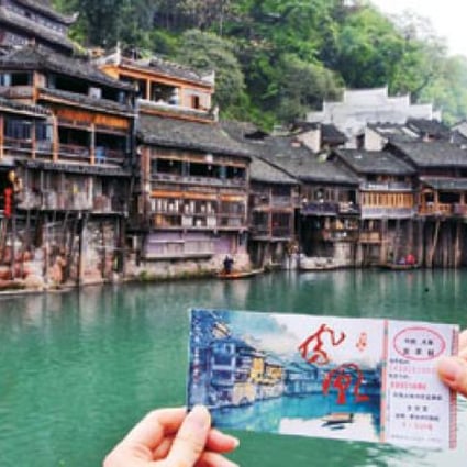 A visitor is holding an entry ticket in Fenghuang old town. Photo: Xinhua