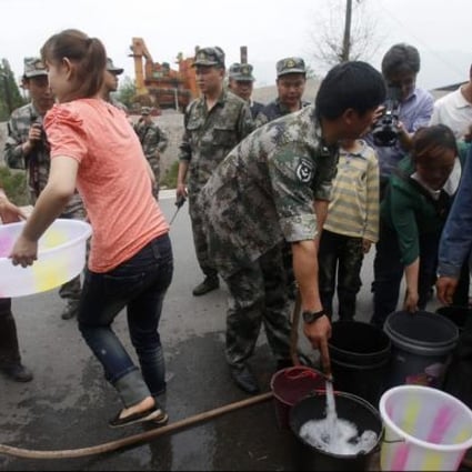 Residents of Longmen collect fresh water from a supply station. Photo: AFP