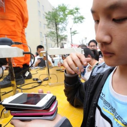 A girl recharges four mobile phones at a time in Yaan, Sichuan, on Sunday. Photo: Xinhua