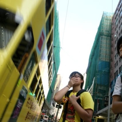 Pedestrians cover their noses to guard against the poor air quality in the busy streets in Causeway Bay. Photo: SCMP