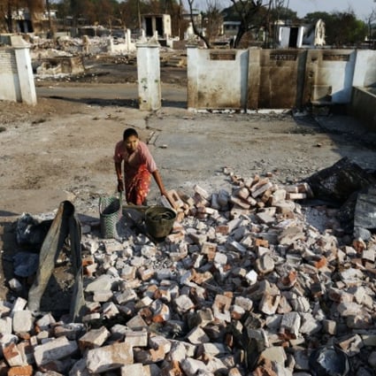 A woman collects bricks and other useful items from burnt Muslim homes in Meikhtila. Photo: Reuters