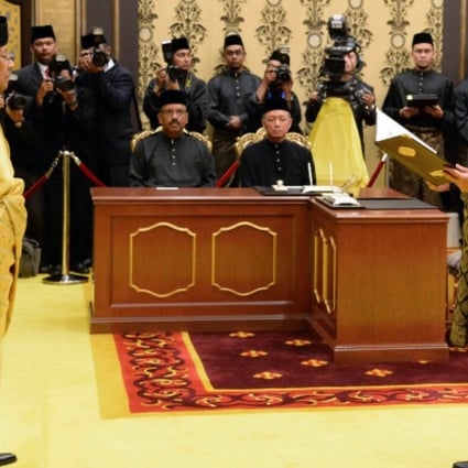 Malaysia's Prime Minister Najib Razak (right) reads his oath declaration in front of Malaysia's King Abdul Halim Mu'adzam Shah as he is sworn in for his second term as prime minister at the National Palace. Photo: AFP