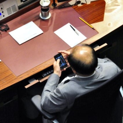 Eddie Ng is seen checking his smartphone. Photo: SCMP