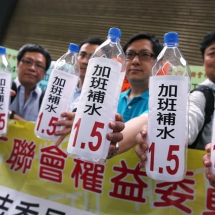 Unionists protest outside where the Standard Working Hours Committee was meeting. Photo: Sam Tsang