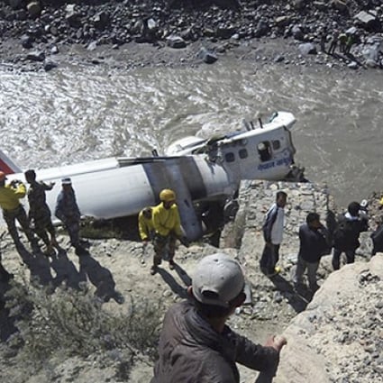 Rescuers stand near the wreckage of a Nepal Airlines plane that crashed on the banks of Kaligandaki river at Jomsom, some 200km northwest of Katmandu, Nepal, on Thursday. Photo AP