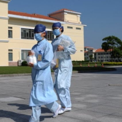 Two nurses walk in front of building A3 at an isolation hospital in southwest Shanghai. Photo: AFP