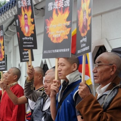 Tibetans display portraits of people who killed themselves in self-immolation, during a protest in front of the Liberty Square in Taipei. Photo: AFP