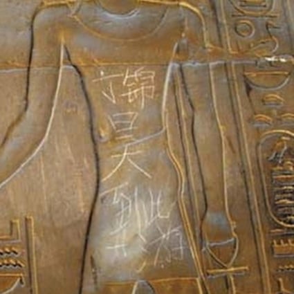 Graffiti reading 'Ding Jinhao was here' lies scratched into a piece of Egyptian artwork in the 3,500-year-old Temple of Luxor in Cairo.
