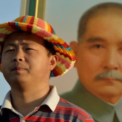 A Chinese tourist poses in front of a portrait of Sun Yat-sen at Tiananmen Square in Beijing. Photo: AFP