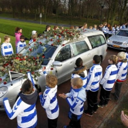 Members of Dutch soccer club SC Buitenboys lay roses on the hearse carrying the body of Richard Nieuwenhuizen at a crematory in Almere, Netherlands, on December 10 2012. Photo: Reuters