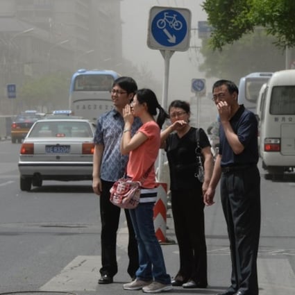 Pedestrians try to protect themselves against choking traffic fumes in Beijing. Photo: AFP