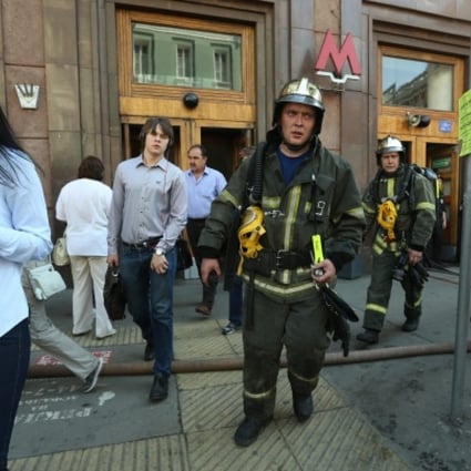 Passengers and fire fighters leave the metro station Okhotny Riad in the center of Moscow. Photo: EPA