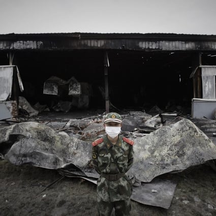 A paramilitary policeman guards the burnt-out plant. Photo: Reuters