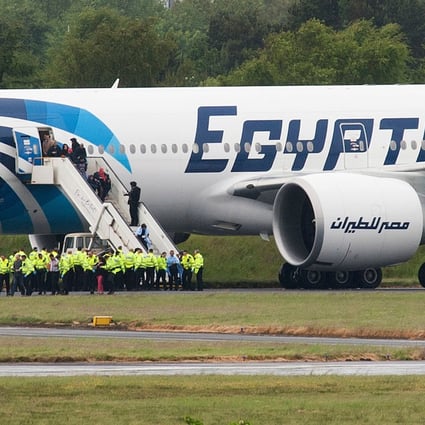 Police escort passengers off the EgyptAir Boeing 777 flight from Cairo that was forced to land at Glasgow Prestwick airport in Scotland. Photo: AFP