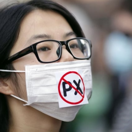A protester wears a mask with a reference to the dangerous chemical paraxylene that the Ningbo plant already produces. Photo: Reuters