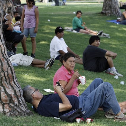 People gather in the shade at Belvedere Lake Park, Los Angeles, as a heat wave grips the western US. Photo: Reuters