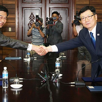 Suh Ho (right), head of the South Korean working-level delegation, shakes hands with his North Korean counterpart Park Chol-Su after their talks. Photo: AFP