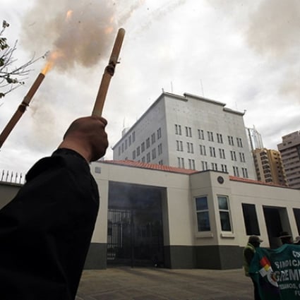Demonstrator launch firecrackers outside the US embassy during a protest in La Paz. Photo: AP
