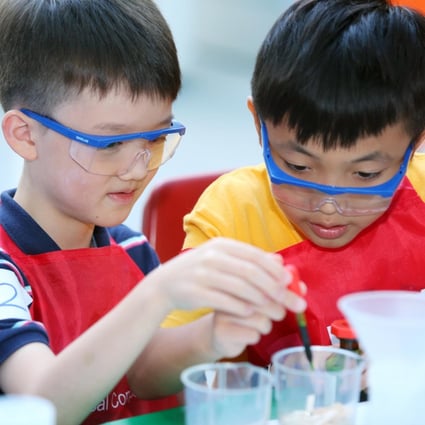 Bill Koo (left) and Herman Chan performing water purification experiments in the Kids Lab.