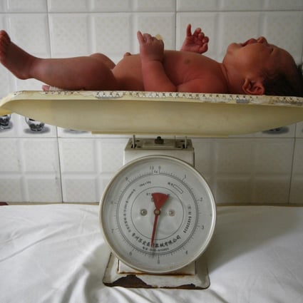 A baby cries on a weighing scale at a local hospital in Suining, in southwest China's Sichuan province. Photo: AP