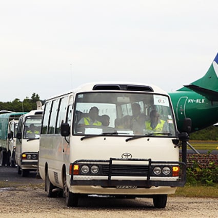 The first group of 40 asylum-seekers arrive in mini-buses shortly after landing on Manus Island, Papua New Guinea, formally bringing into effect the Regional Settlement Arrangement on Thursday. Photo: AFP