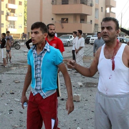 Injured men walk away from an explosion in the northern Syrian city of Raqqa. UN weapons inspectors tasked with looking into claims of chemical weapons use in Syria are now planning to leave. Photo: AFP