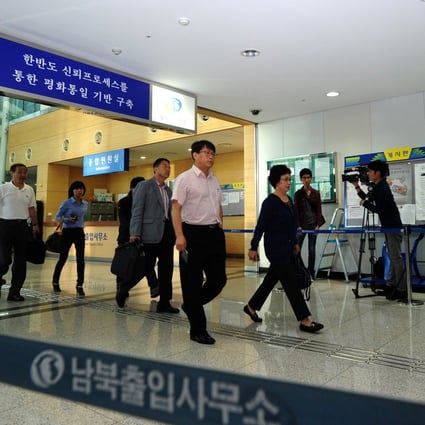 Businessmen and women walk through a border checkpoint in Paju near the Demilitarised Zone (DMZ) dividing the two Koreas as people head back to the North's Kaesong industry complex. Photo: AFP
