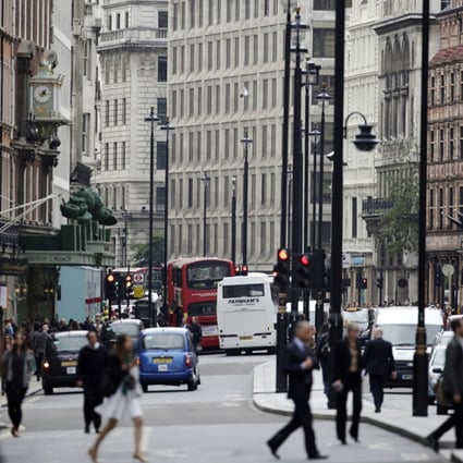 Pedestrians cross the road as traffic passes along Piccadilly in London. Photo: Bloomberg