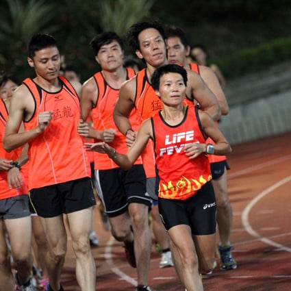 Kate Cheung helps guide blind and deaf runners at Hammer Hill Sports Ground, Choi Hung. Photo: SCMP Pictures