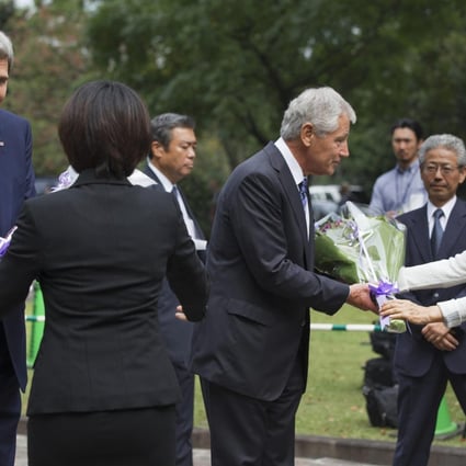 Kerry (left) and Hagel receive flowers at the cemetery. Photo: Reuters