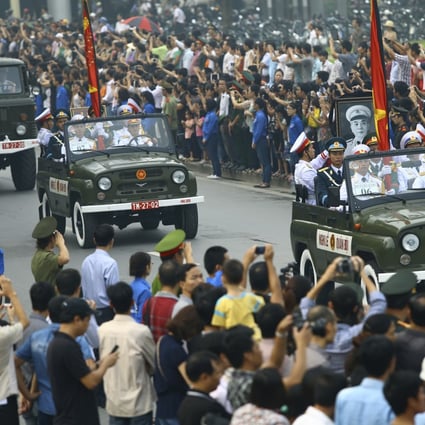 The convoy carrying the coffin of Vietnam's late General Vo Nguyen Giap passes by mourners gathered in front of the Ho Chi Minh Mausoleum in Hanoi. Photo: AP