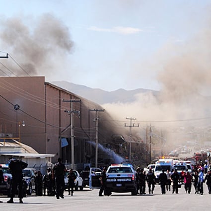 Police and rescue workers gather at Dulces Blueberry confectionery factory after an explosion in Ciudad Juarez, Mexico on Thursday. Photo: AP