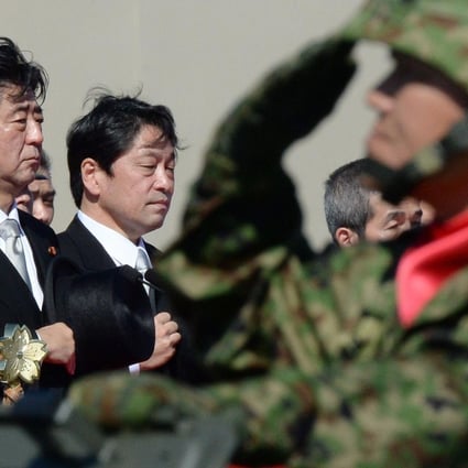 Shinzo Abe (left), inspecting troops yesterday, said the security environment surrounding Japan was becoming increasingly severe. Photo: AFP