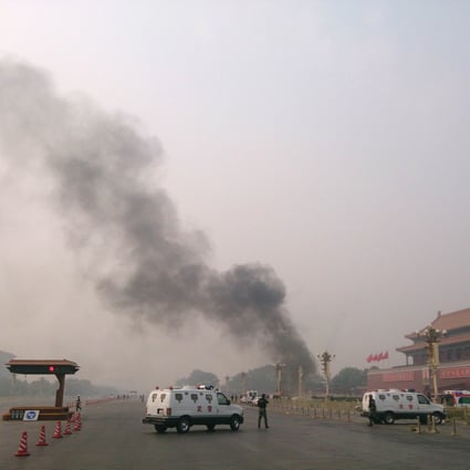 Police cars block off the roads leading into Tiananmen Square as smoke rises into the air after a vehicle crashed in front of Tiananmen Gate in Beijing on Monday. Photo: AFP