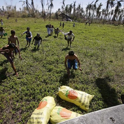 Typhoon survivors rush to grab sacks of rice delivered by the Philippine army in devastated Leyte province yesterday. Photo: EPA