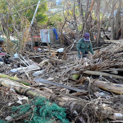 A woman salvages what is left of her belongings from her flattened house in an area devastated by Super Typhoon Haiyan. Photo: AFP