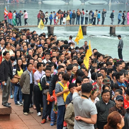 People queue to board tour boats to visit Fenghuang, central China's Hunan province, during Golden Week. Photo: Xinhua