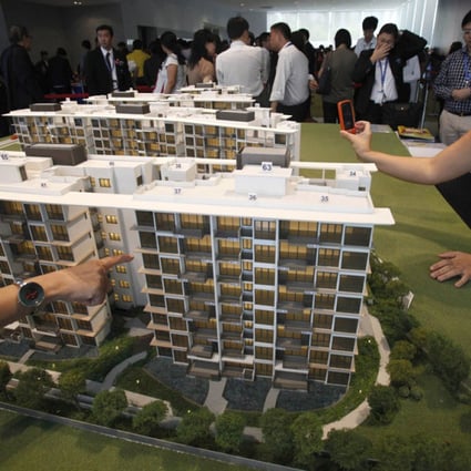 Prospective buyers look at a model of a condo development. Photo: Reuters
