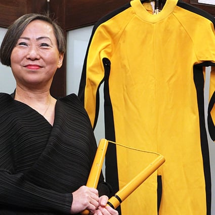 Anna Lee, Vice Chairman of Spink, shows Bruce Lee's nunchaku and jumpsuit on the media preview of Bruce Lee 40th anniversary collection auction in Wanchai. Photo: Edward Chan