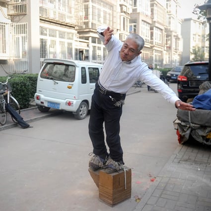 For the past seven years, Zhang Fuxing has walked in iron shoes, in what he views as a healthy habit. Here, he is taking a stroll in a residential district in Tangshan, Hebei province. Photo: AFP