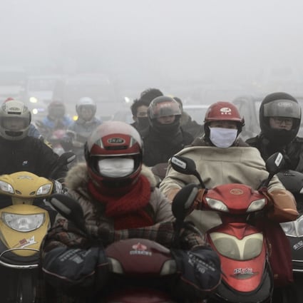 Residents wearing masks ride their electric bicycles on a street amid heavy haze in Shaoxing, Zhejiang province. Photo: Reuters