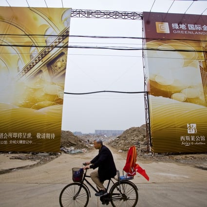 A man bikes by an empty lot to be developed by Greenland company in Wuhan. Greenland has 241 of the 250 apartments released in the first stage of Greenland Centre in Sydney. 